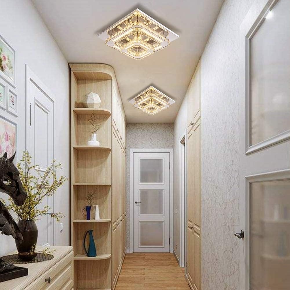 Modern hallway with wooden shelves, decorative lights, and a door.