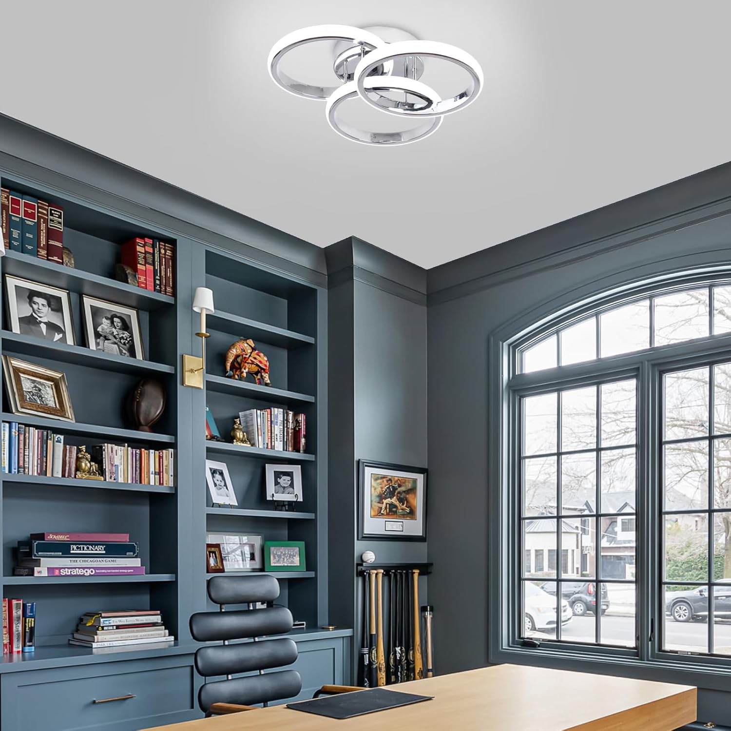 Modern home office with bookshelves, desk, and large window.