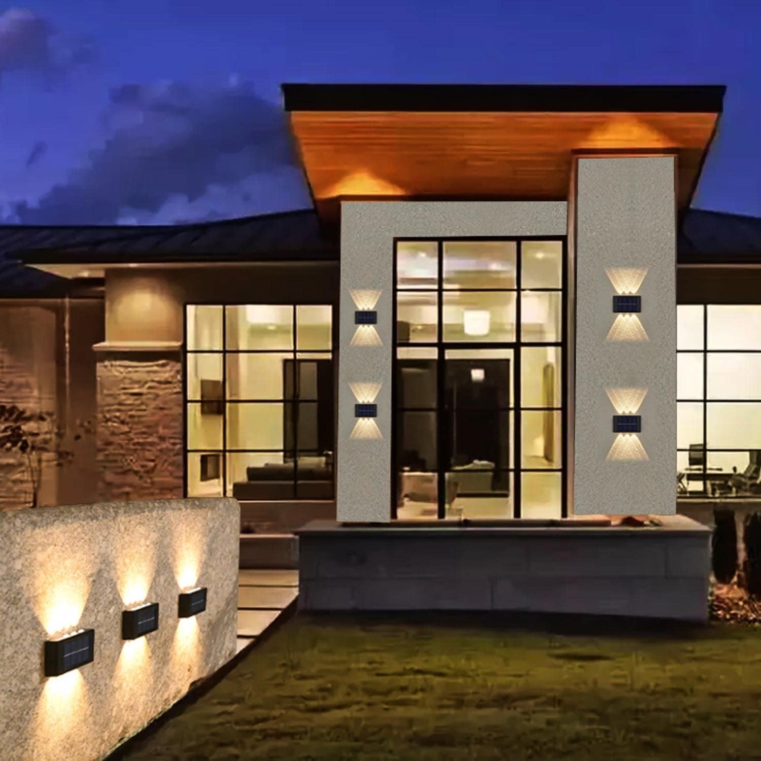 Modern house exterior with illuminated windows and outdoor lighting at night.
