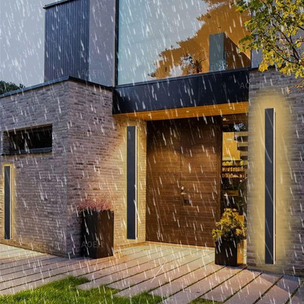 Modern house exterior with rain falling, featuring a brick facade and glass windows.