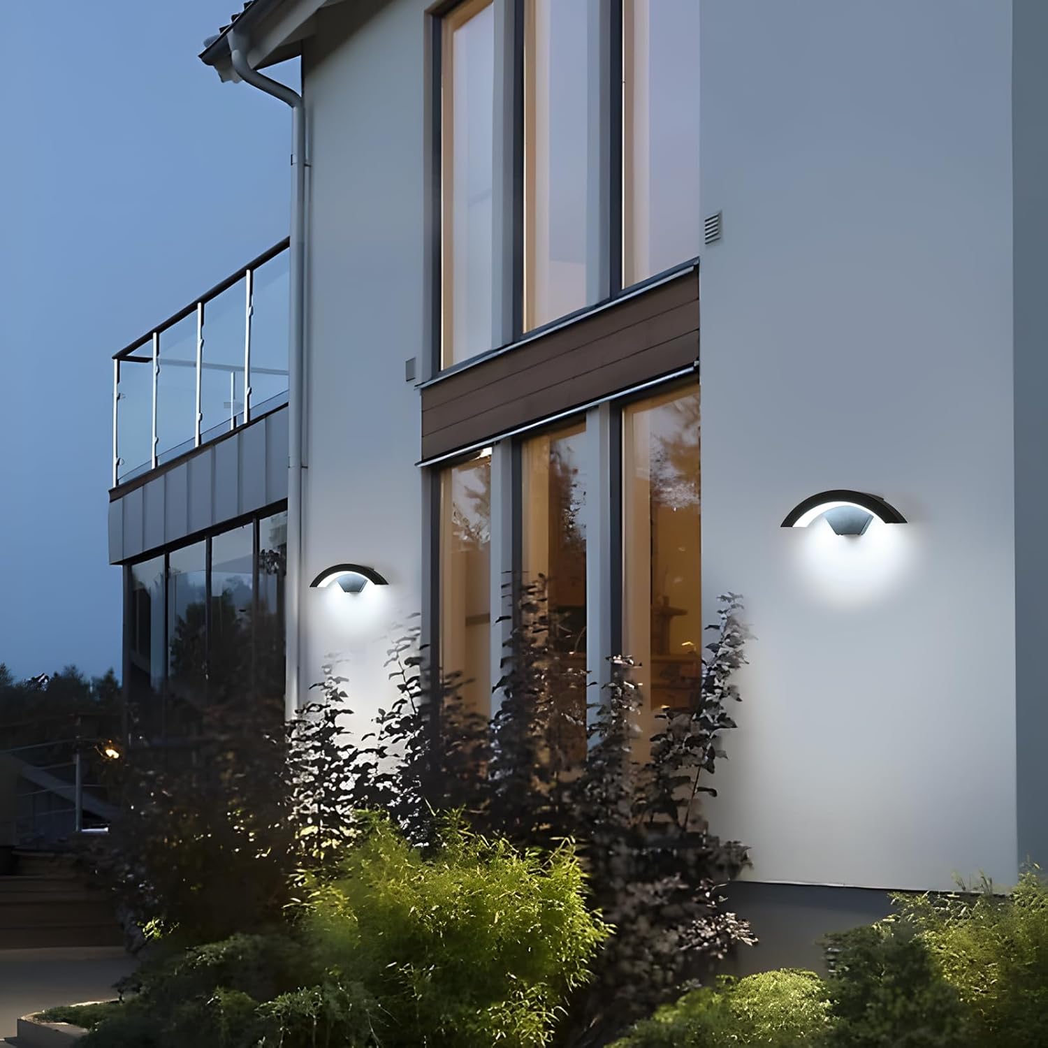 Modern house exterior with wall-mounted lights at dusk