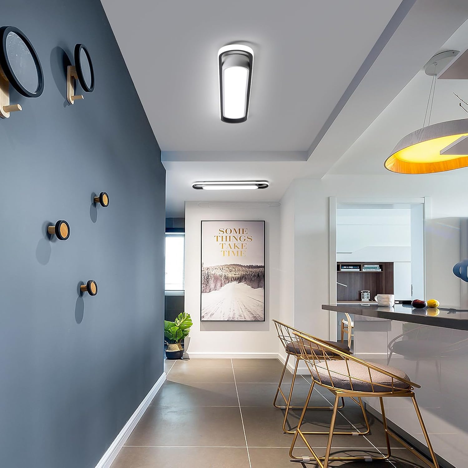 Modern interior design with a blue wall, gold chairs, and a kitchen area.