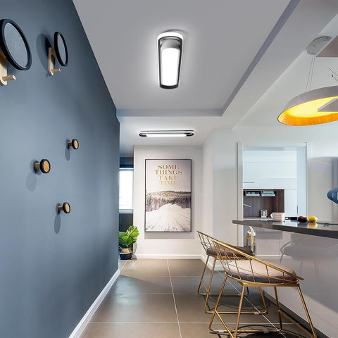 Modern interior design with a blue wall, gold chairs, and a kitchen area.