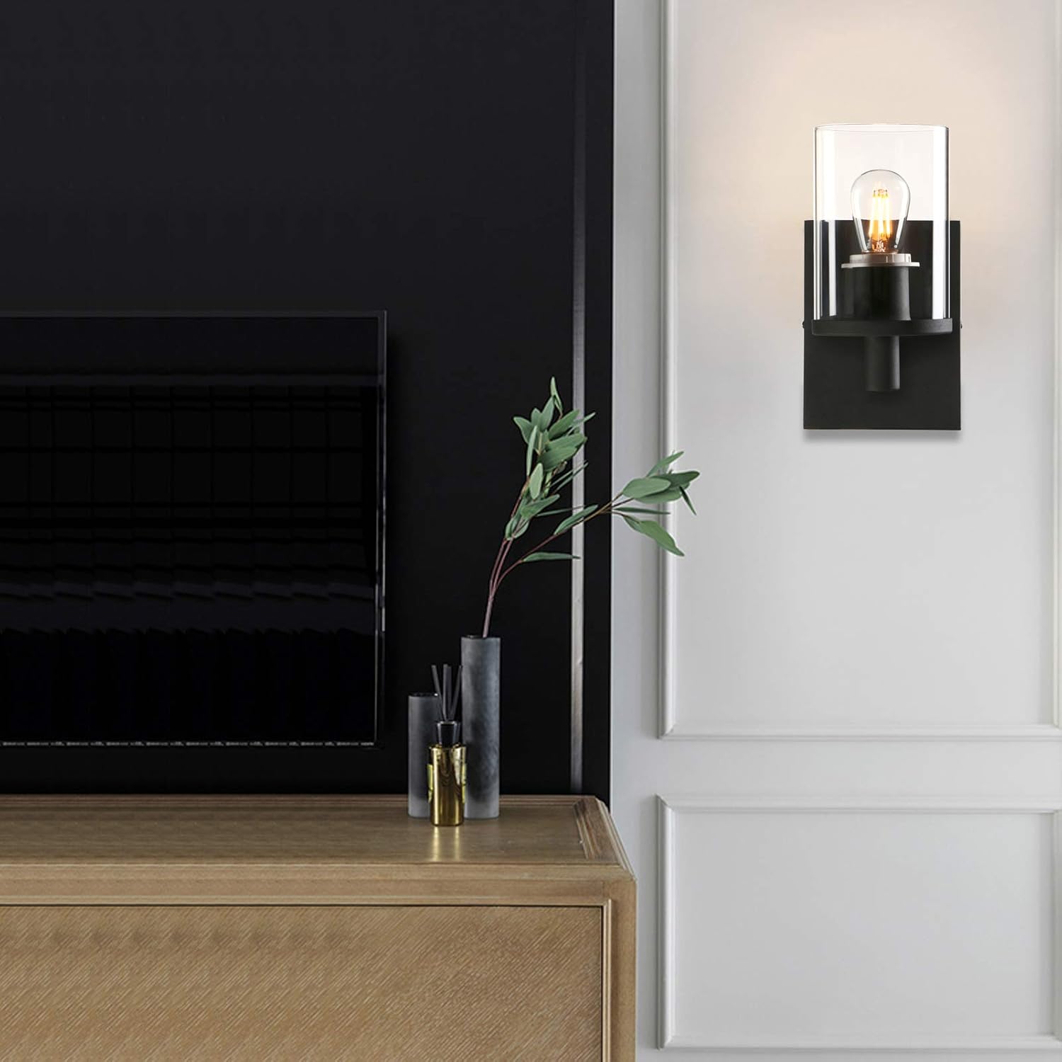 Modern interior with a black wall-mounted light fixture, wooden cabinet, and decorative items.