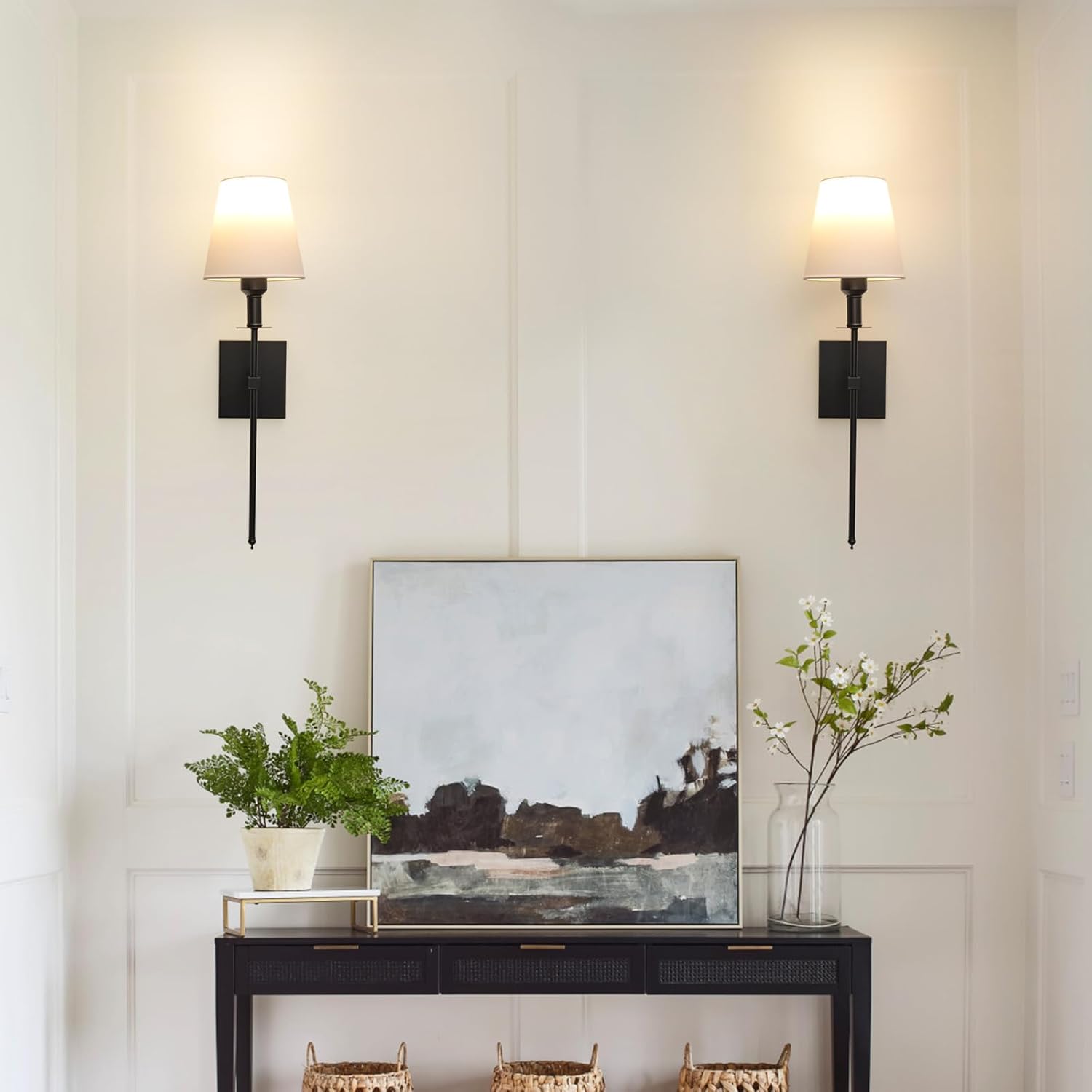 Modern interior with a console table, abstract painting, and decorative items against a light wall.