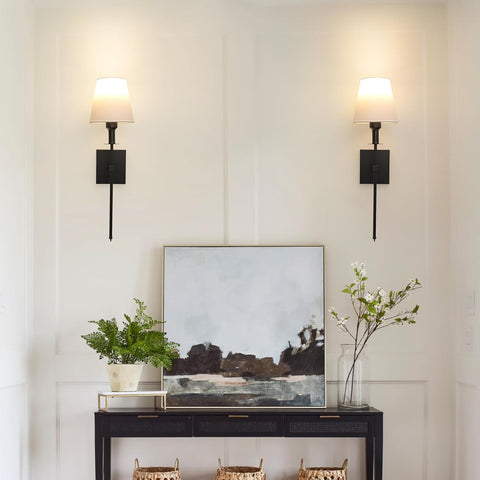 Modern interior with a console table, abstract painting, and decorative items against a light wall.