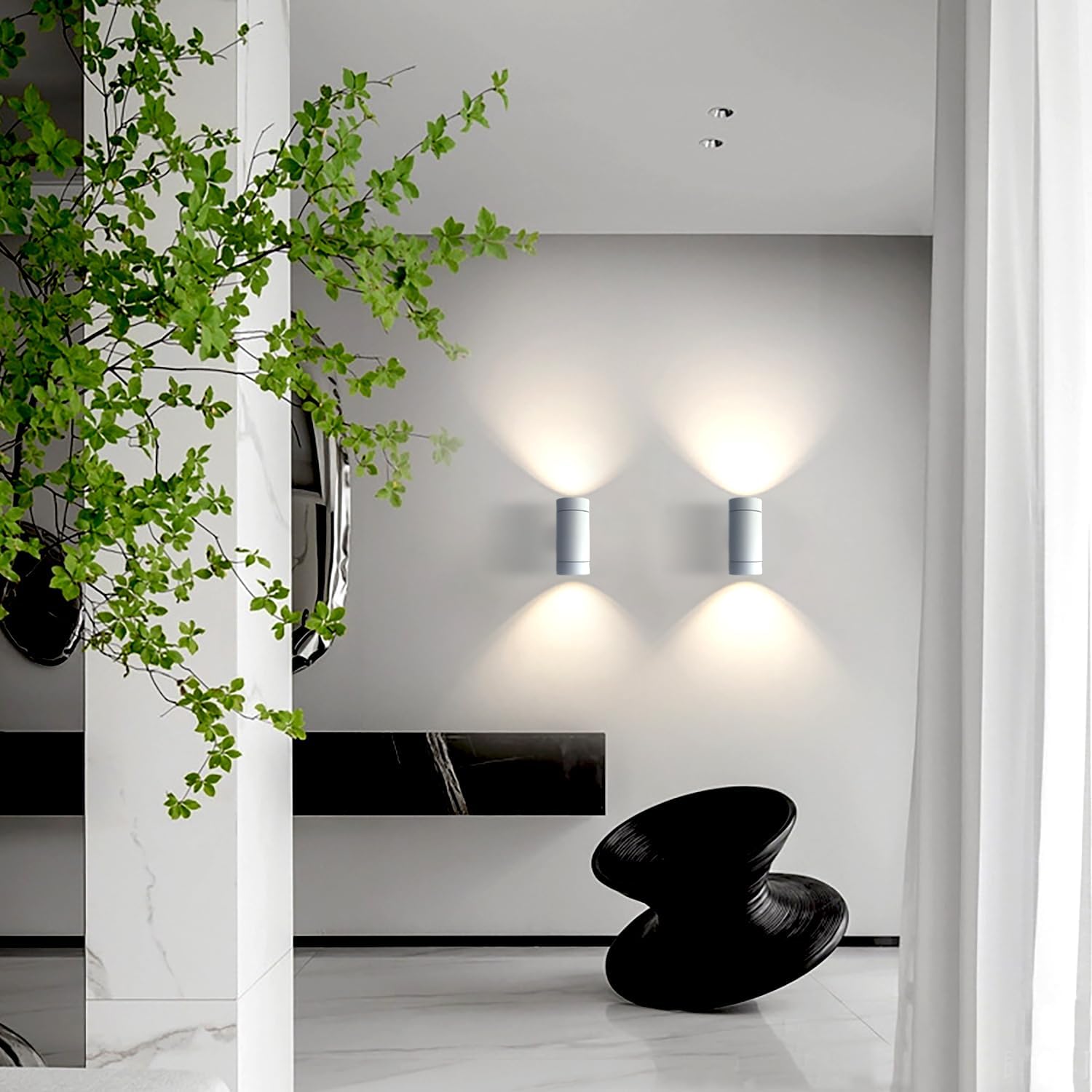 Modern interior with wall lights, a black stool, and green plant.