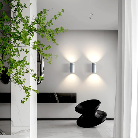 Modern interior with wall lights, a black stool, and green plant.