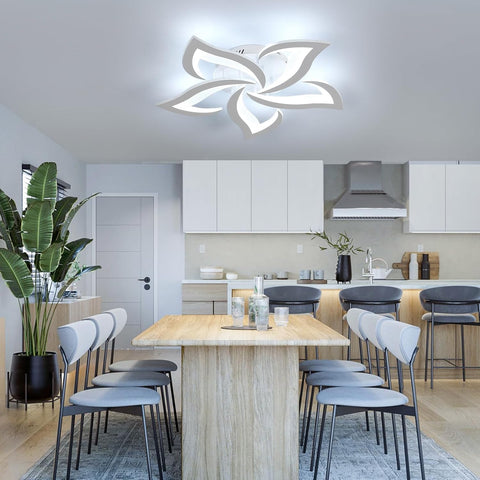 Modern kitchen with a ceiling light fixture, dining table, and chairs.