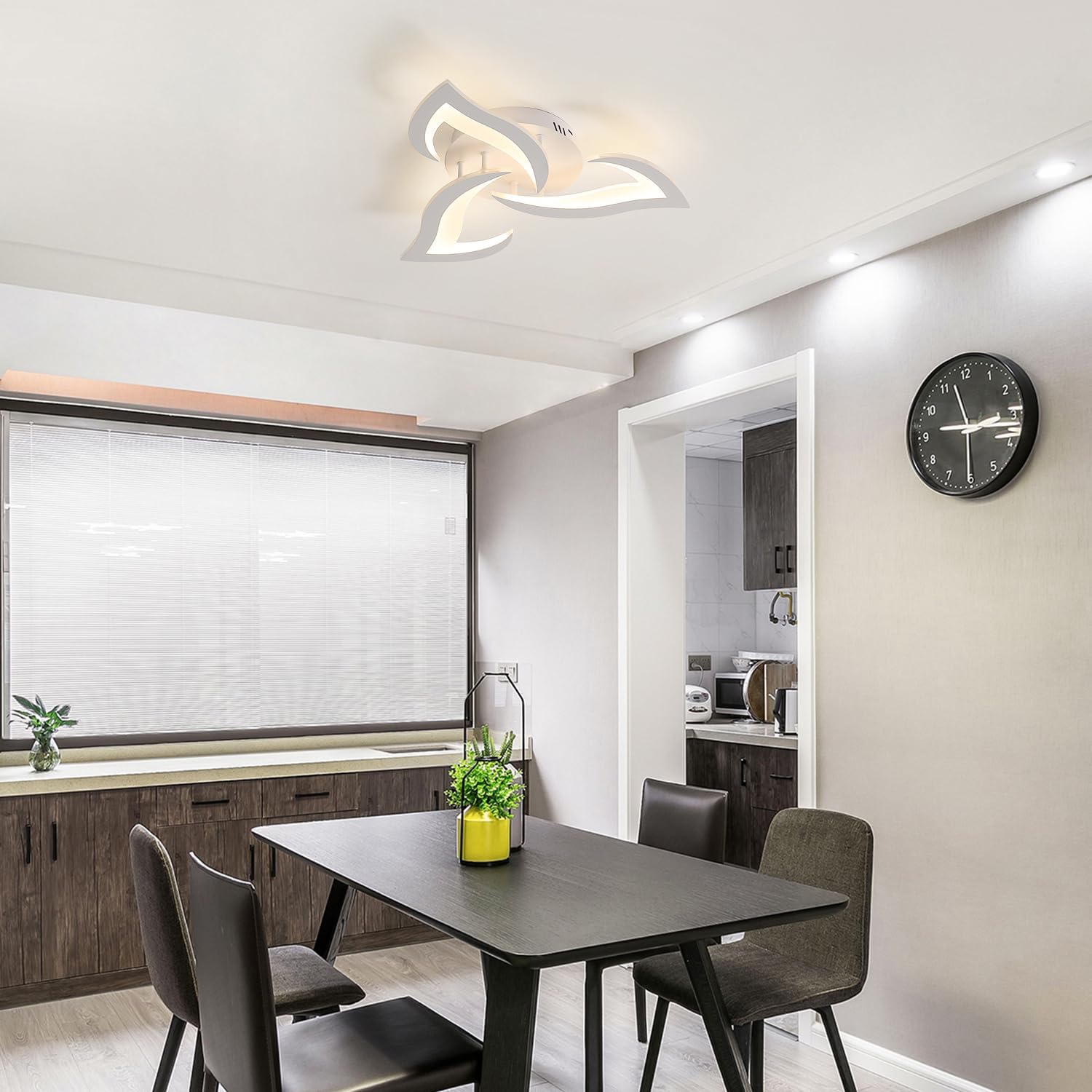 Modern kitchen with dining table and chairs, featuring a clock on the wall.