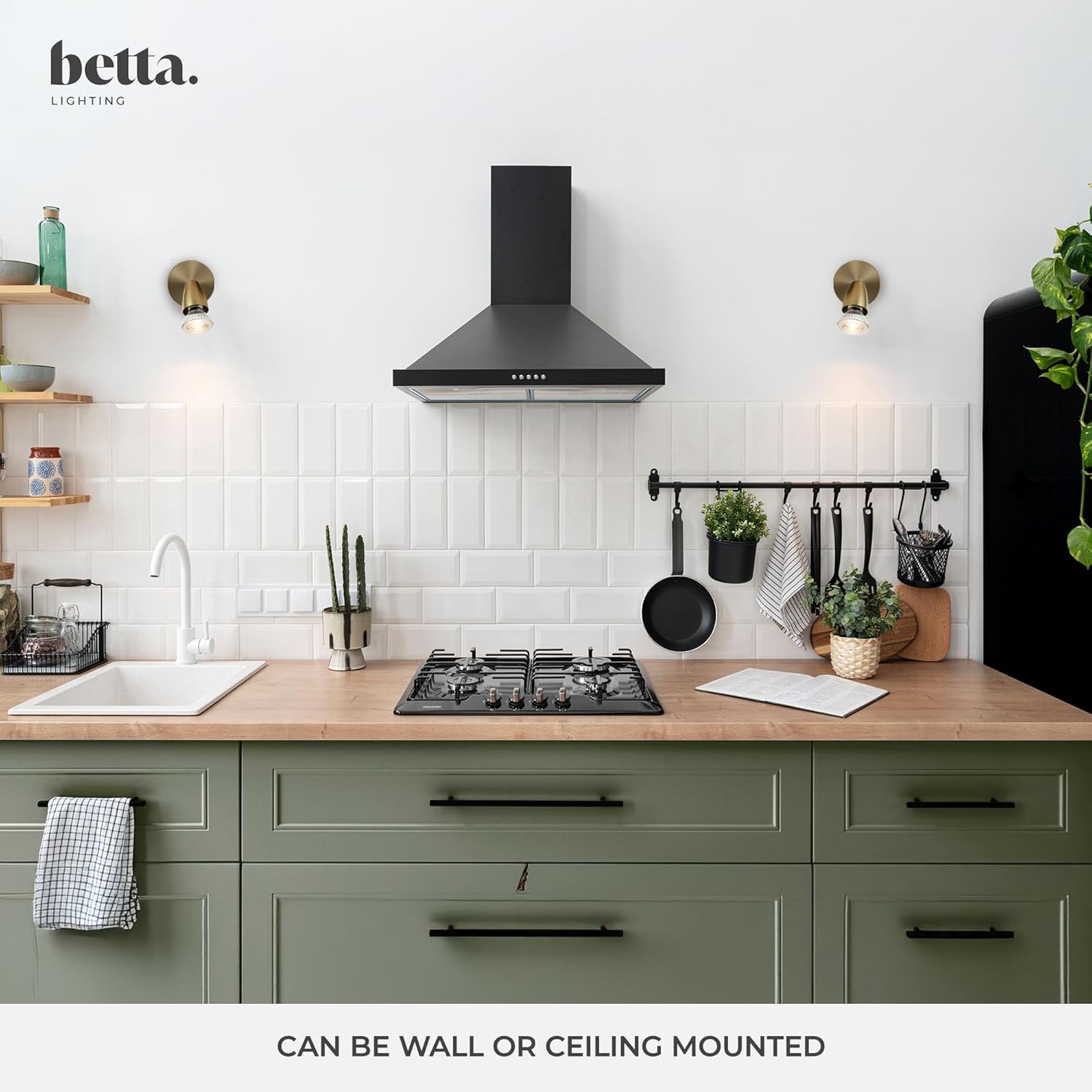 Modern kitchen with green cabinets, black stove, and black range hood, featuring the brand 'betta'.