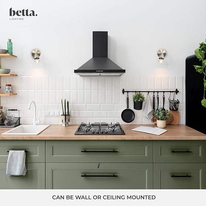 Modern kitchen with green cabinets, black stove, and white tiled wall, featuring betta. branding.