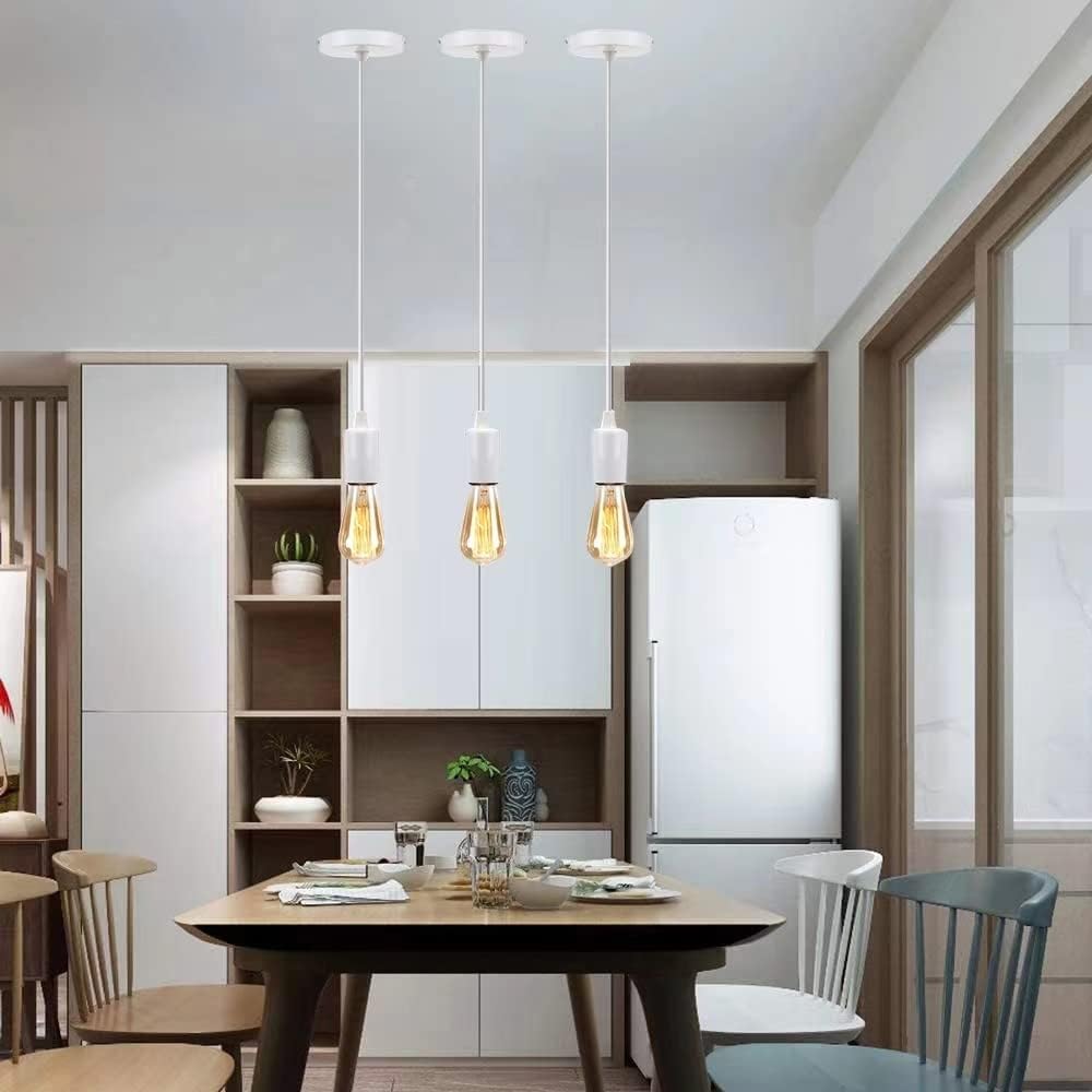 Modern kitchen with pendant lights, wooden table, and chairs.