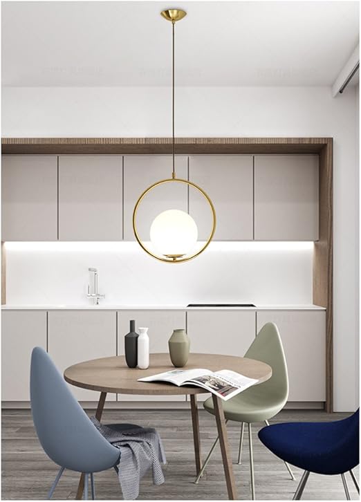 Modern kitchen with round wooden table, chairs, and pendant light fixture.