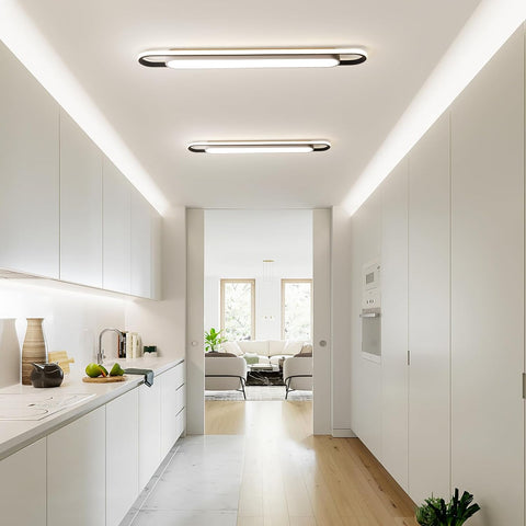 Modern kitchen with white cabinets and a view into a living room.