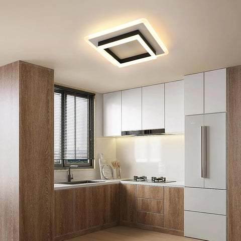 Modern kitchen with wooden cabinets, white appliances, and a ceiling light fixture.