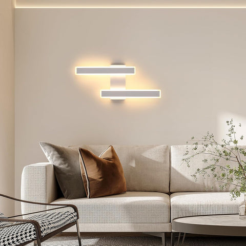 Modern living room with a beige sofa, decorative pillows, and wall lights.