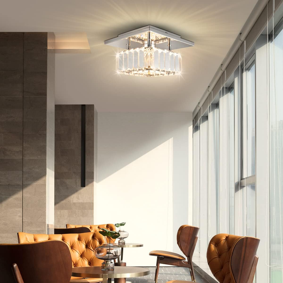 Modern living room with a ceiling light fixture, brown leather sofa, and chairs.