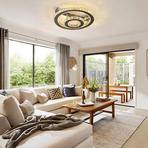 Modern living room with a ceiling light fixture, sofa, coffee table, and decorative elements.
