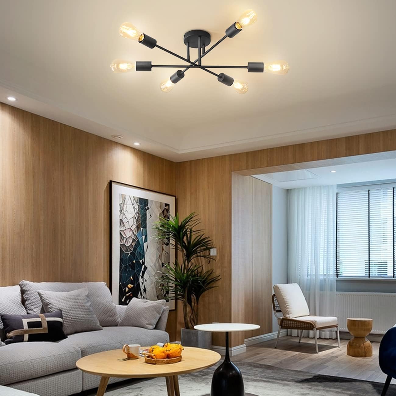 Modern living room with a chandelier, sofa, and decorative elements.