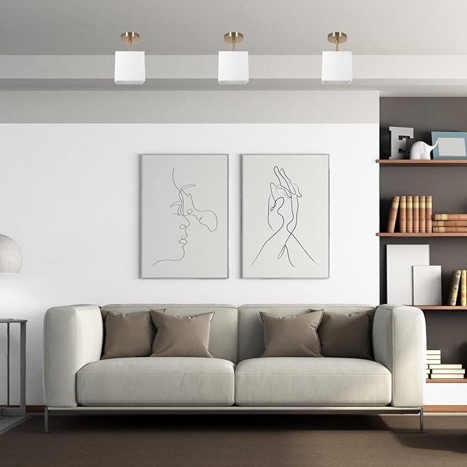 Modern living room with a gray sofa, wall art, and bookshelf.