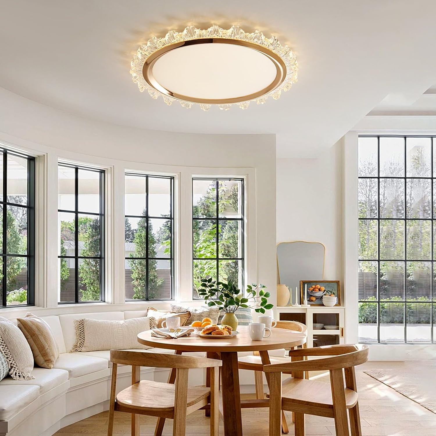Modern living room with a round table, chairs, and a ceiling light fixture.