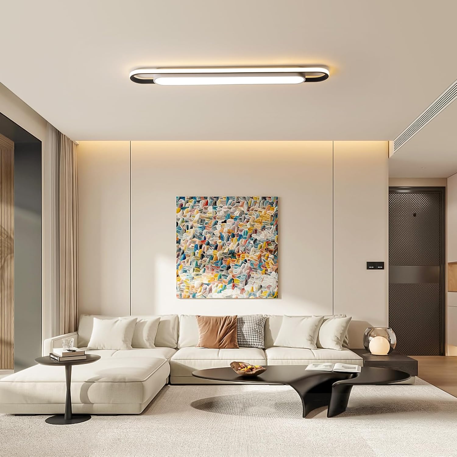 Modern living room with a white sofa, abstract painting, and decorative items.