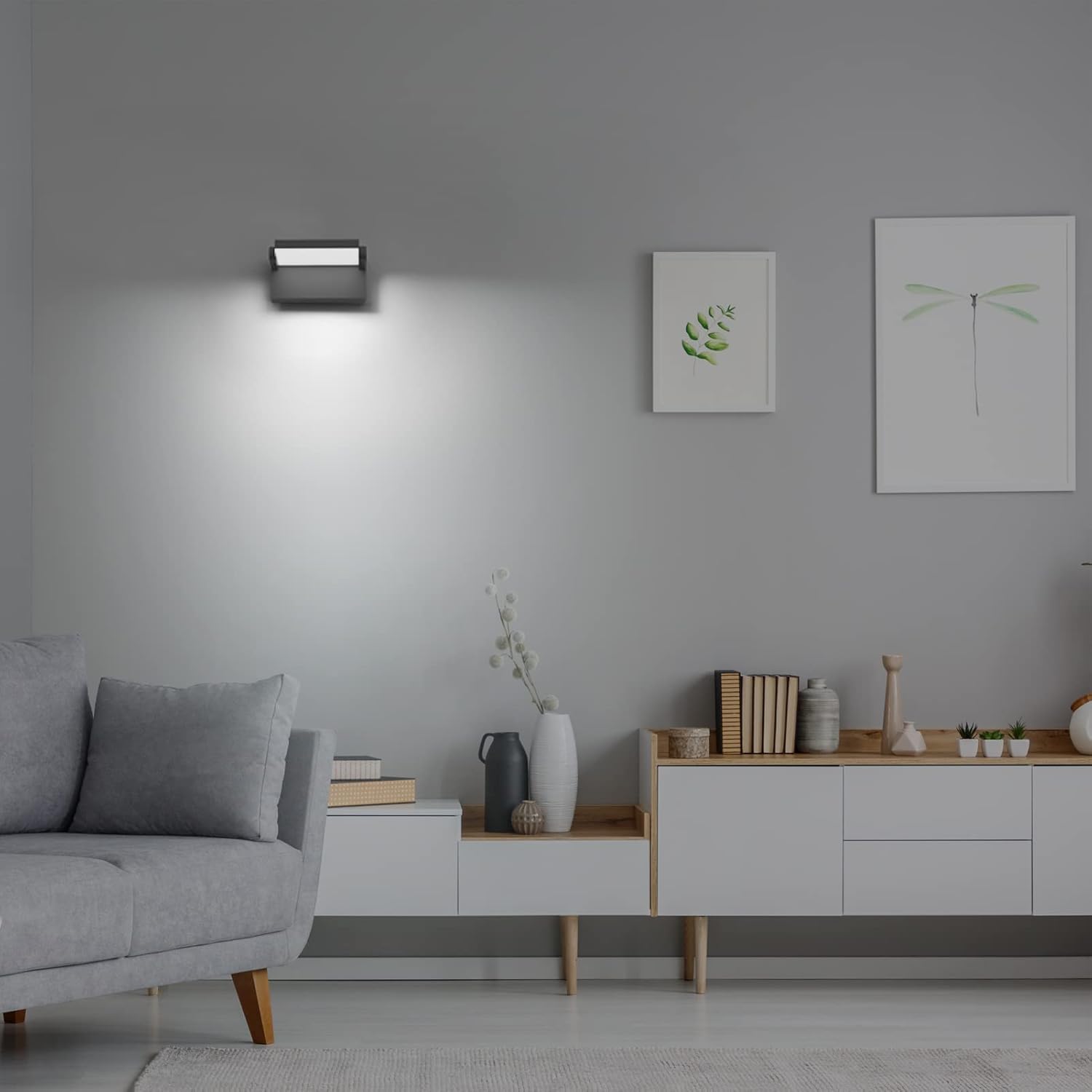 Modern living room with gray sofa, wall-mounted light fixture, and decorative items.