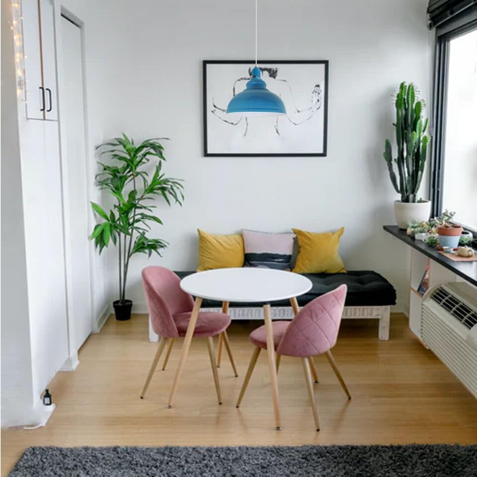Modern living room with pink chairs, white table, and decorative elements.