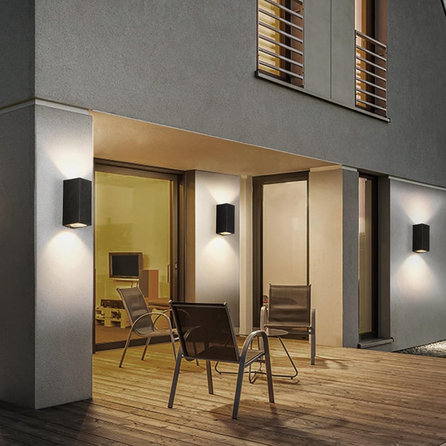 Modern outdoor seating area with chairs and wall lights on a building exterior.
