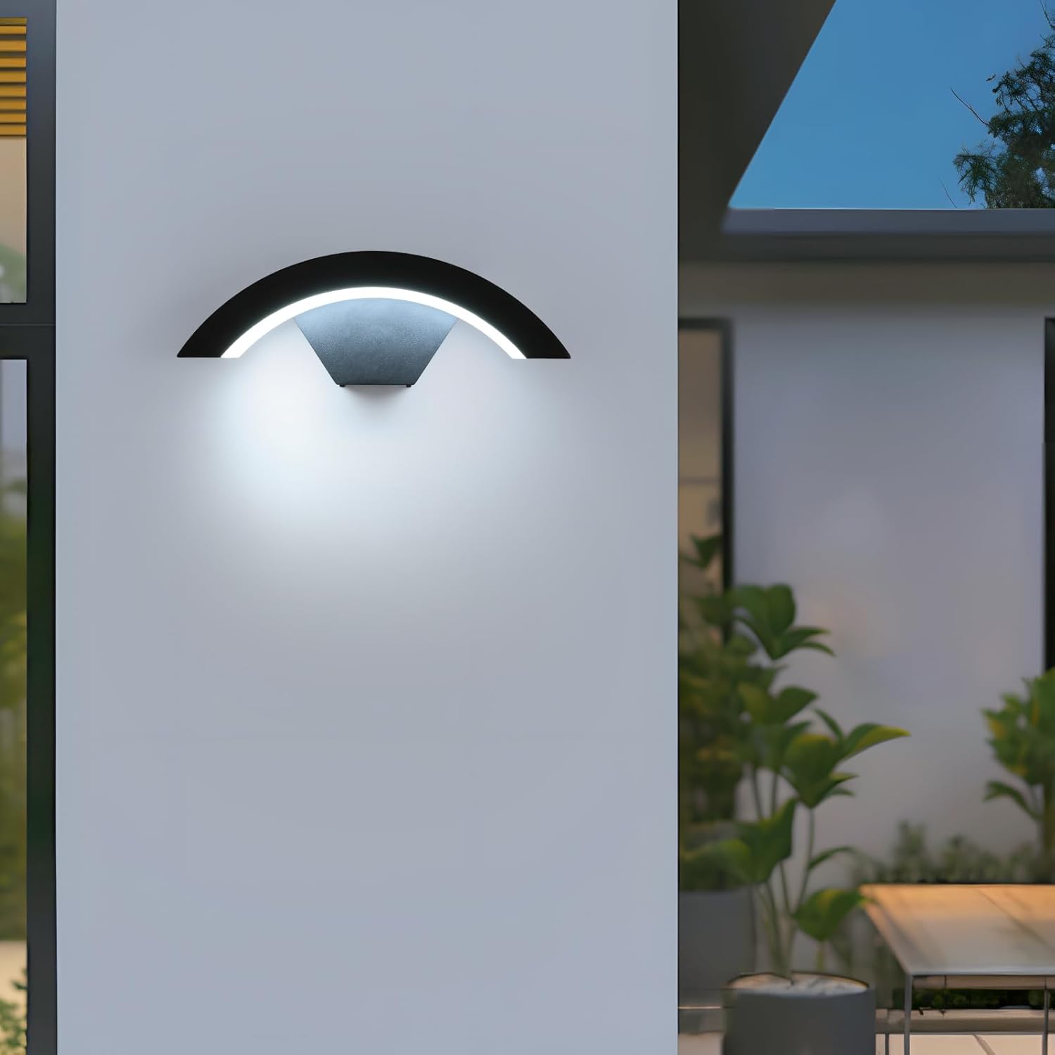 Modern outdoor wall light fixture on a building exterior with plants and furniture in the background.