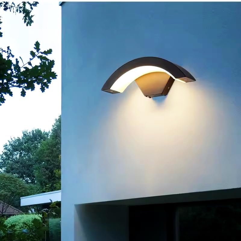 Modern outdoor wall light fixture on a building exterior with trees in the background