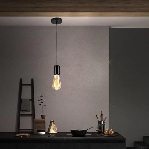 Modern pendant light fixture hanging above a kitchen counter with a neutral wall background.