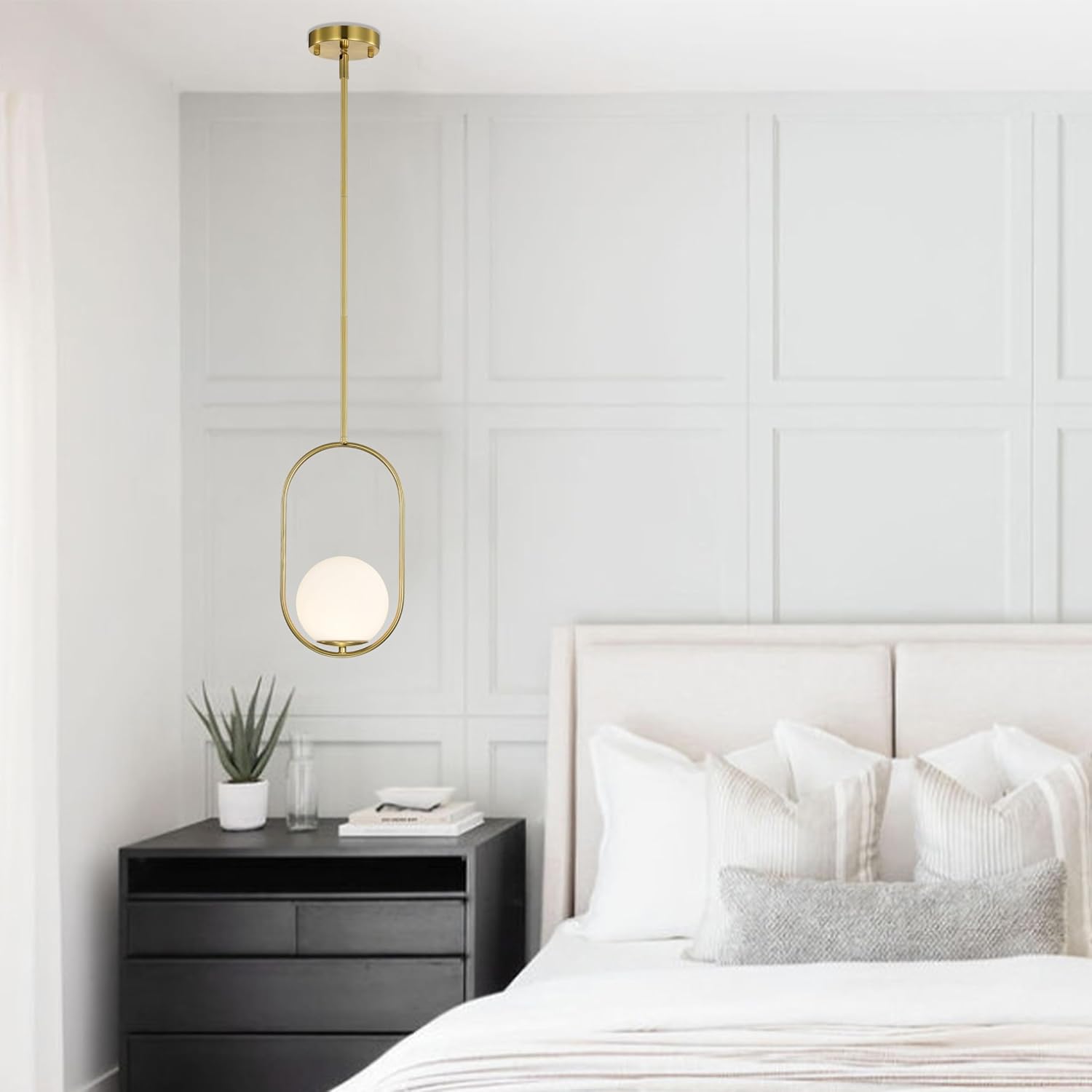 Modern bedroom with a gold pendant light, black nightstand, and white bed.