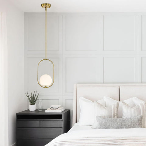 Modern bedroom with a gold pendant light, black nightstand, and white bed.