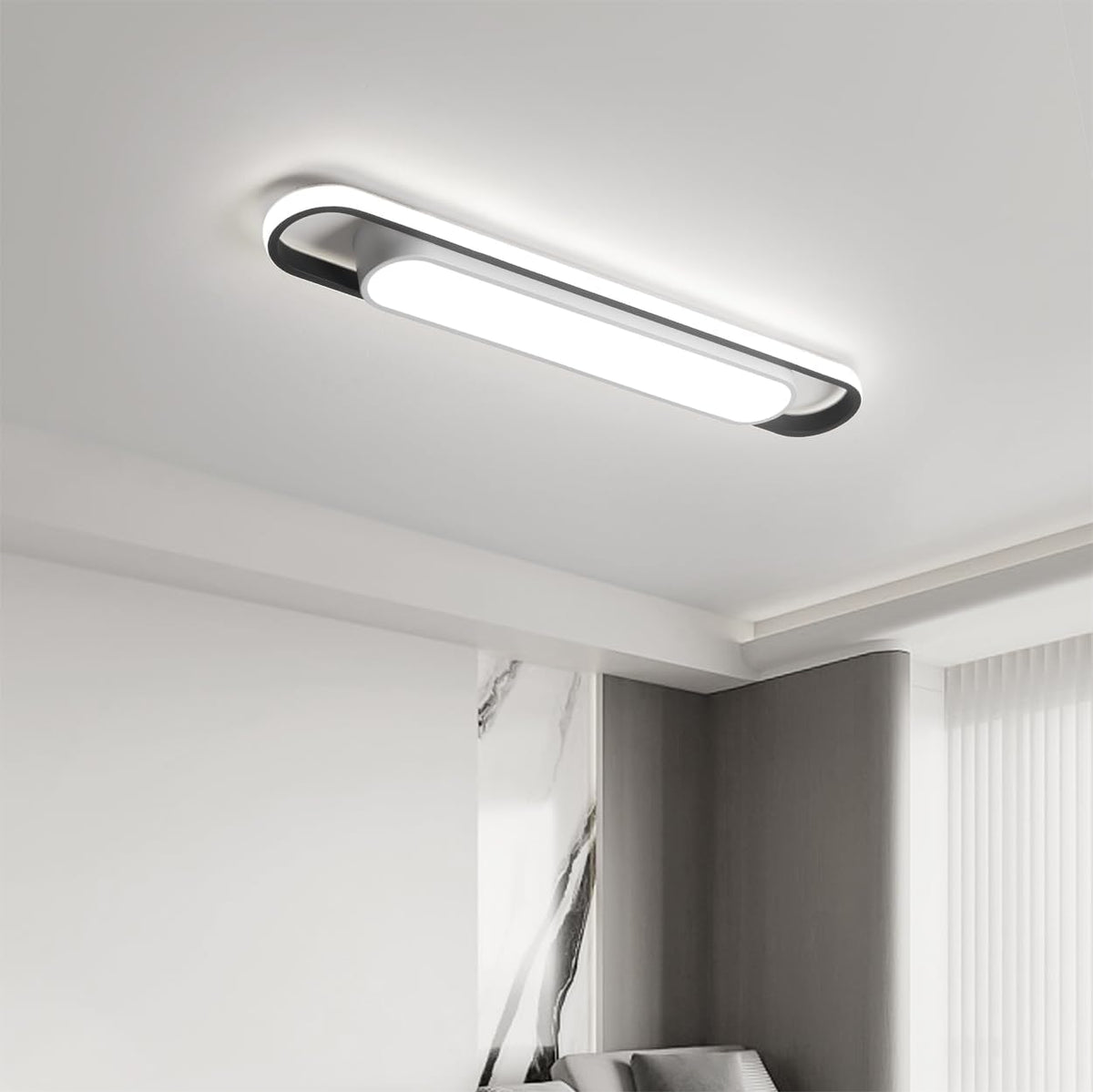 Modern rectangular ceiling light fixture in a room with marble wall and window.