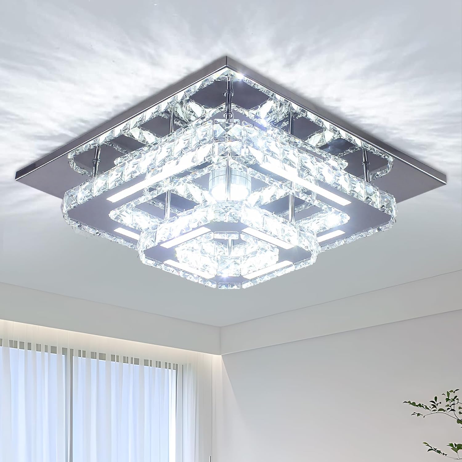 Modern square ceiling light fixture in a room with white walls and a window.