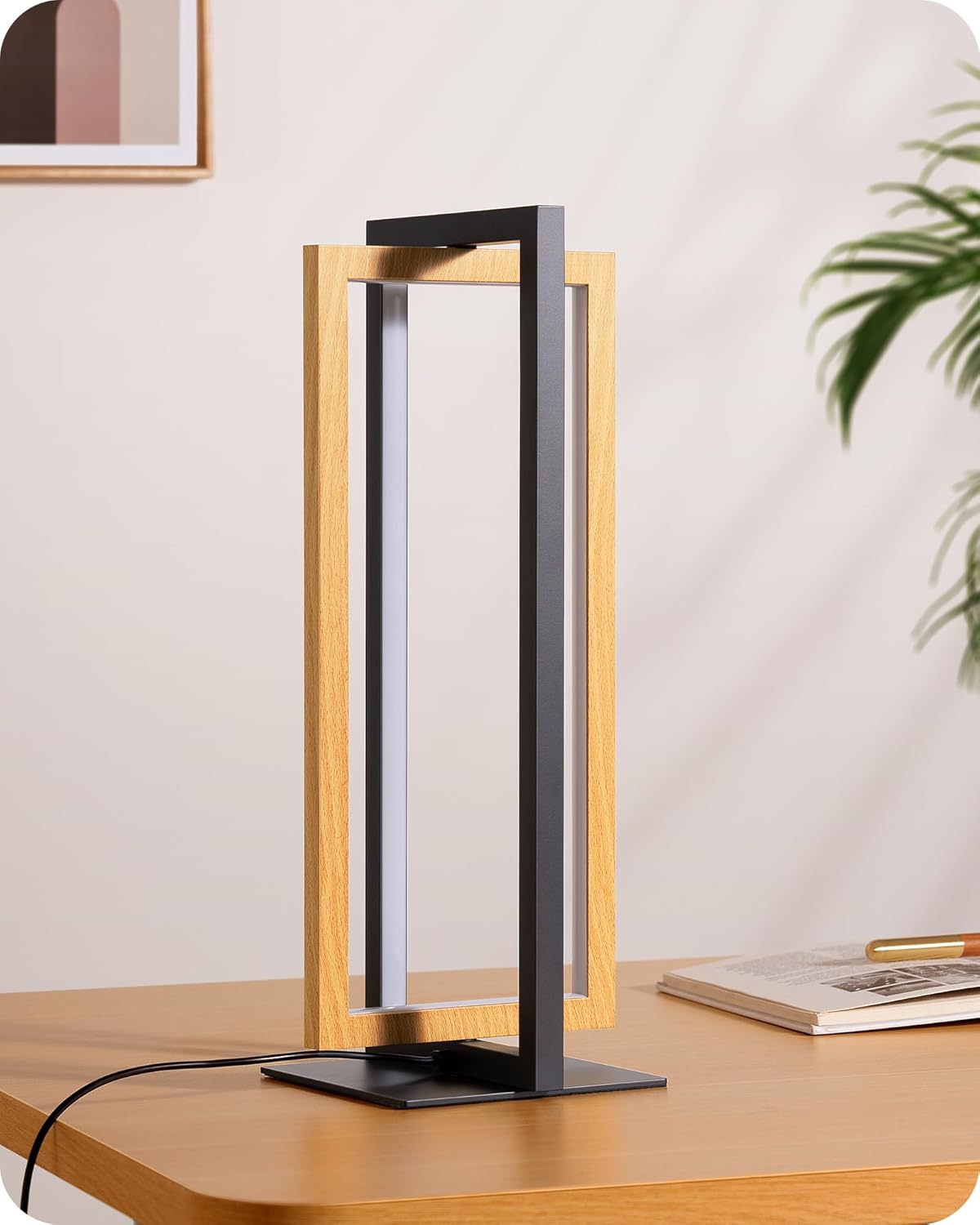 Modern table lamp with wooden frame and black base on a desk.