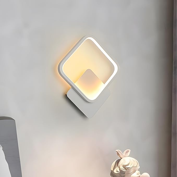 Modern wall-mounted light fixture on a gray wall with a blurred statue in the foreground.