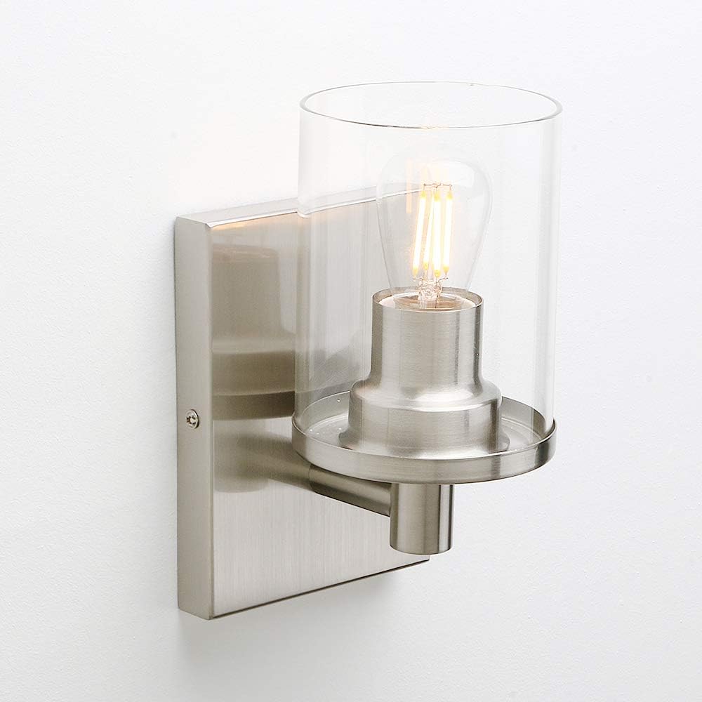 Modern wall-mounted light fixture with clear glass shade on a white background