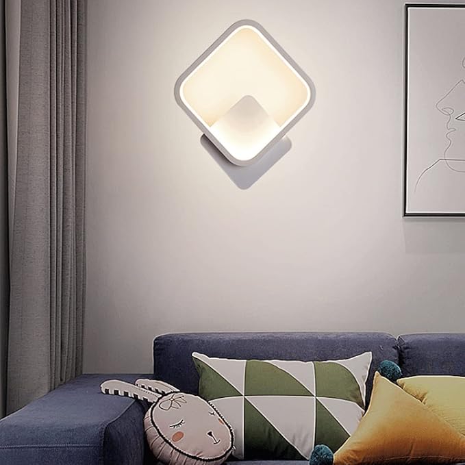 Modern wall lamp above a sofa with decorative pillows in a living room setting.