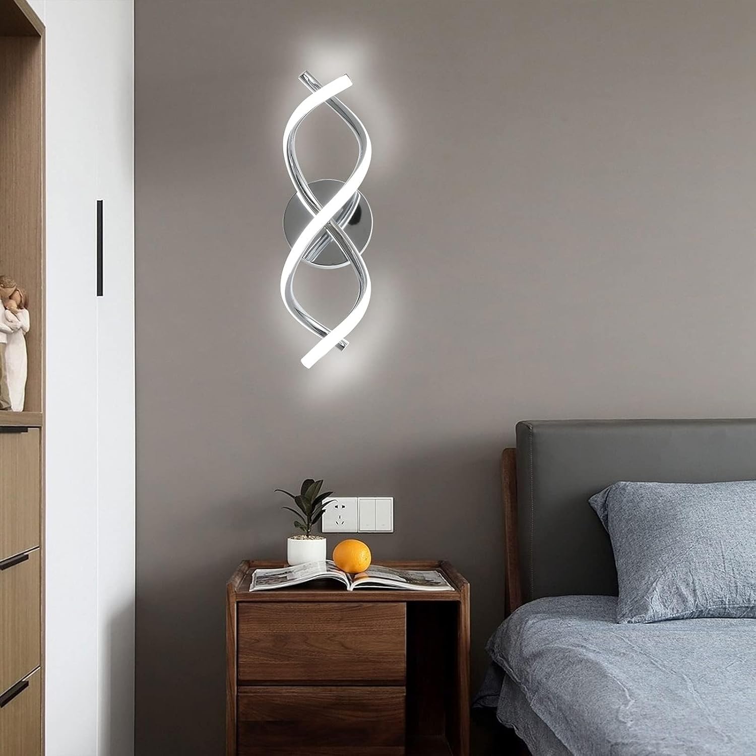 Modern wall light fixture in a bedroom setting with a nightstand and bed.