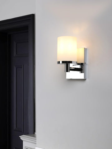 Modern wall sconce on a gray wall next to a dark door