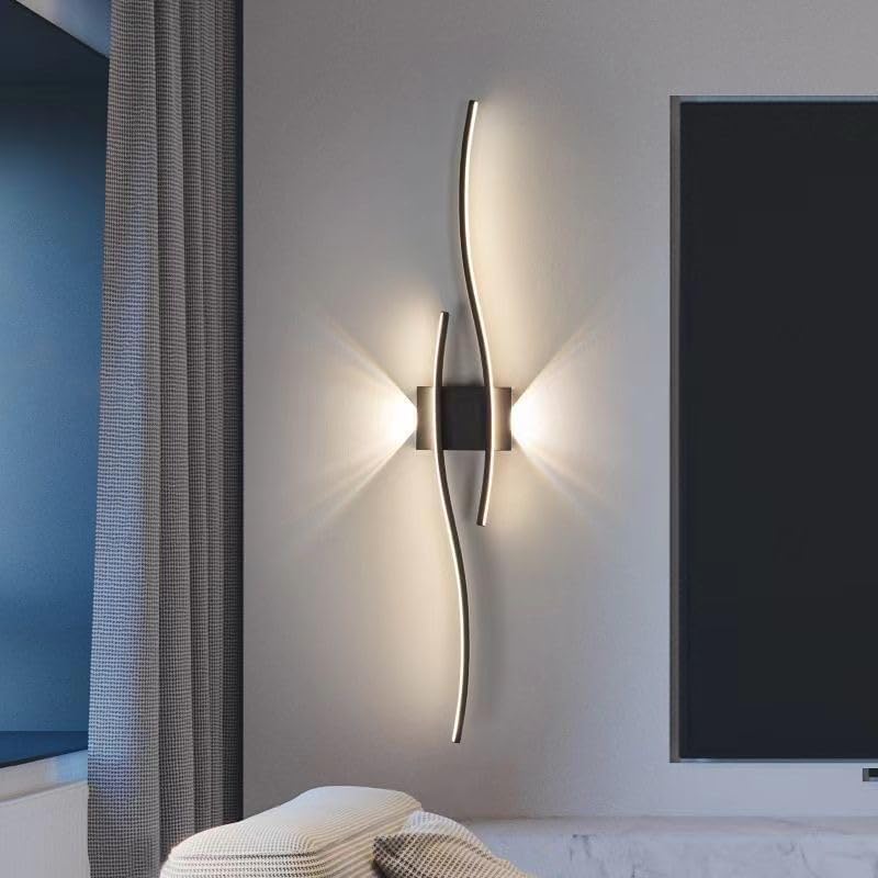 Modern wall sconce on a neutral wall with a television in the background