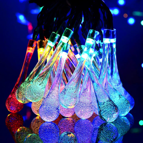 Raindrop-shaped LED lights glowing in various colors at night

