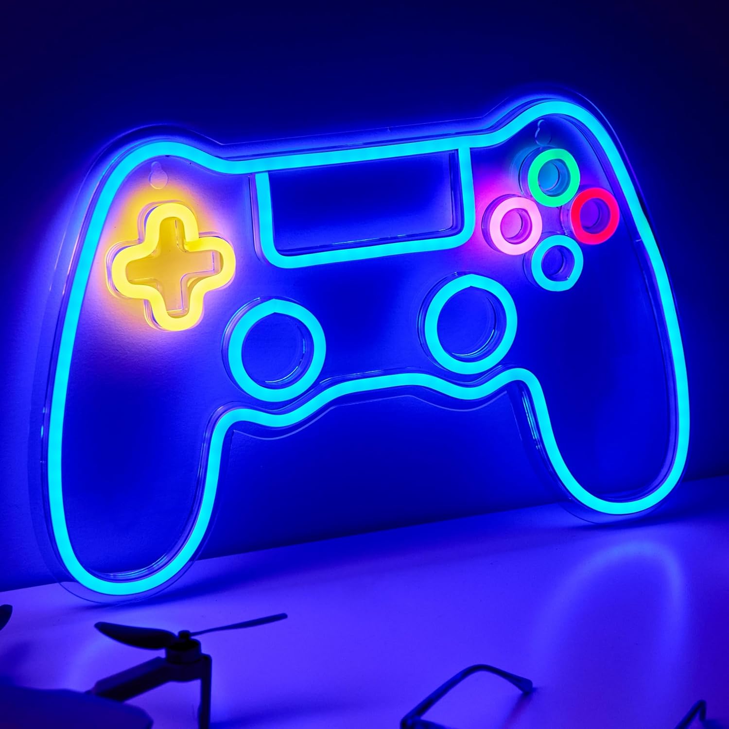 Neon light shaped like a gaming controller on a dark background