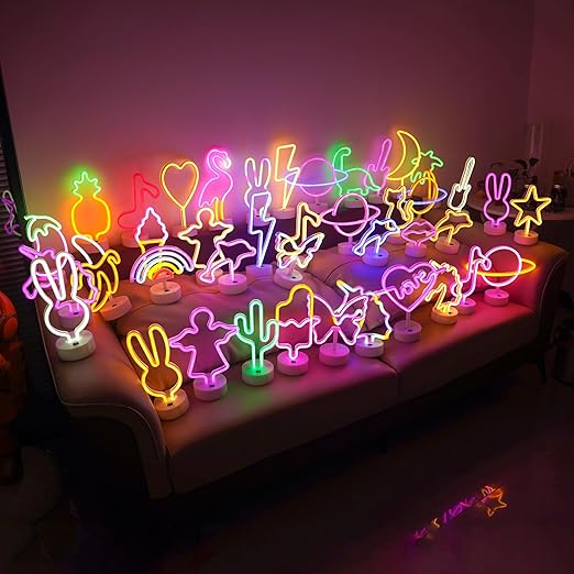 Neon sign shaped like a heart with the word 'love' inside, on a stand against a pink background.