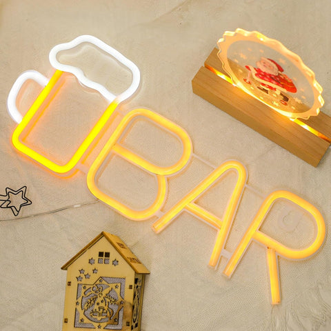 Neon sign with 'BAR' and a small wooden house decoration on a beige surface.