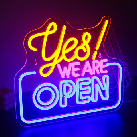 Neon sign with 'Yes! We Are Open' text on a dark background