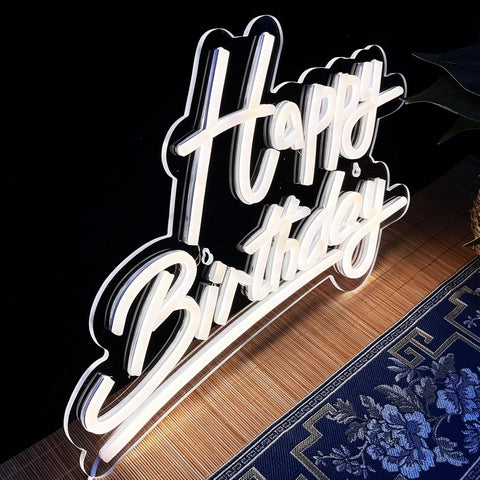 Neon sign with 'Happy Birthday' text on a dark background